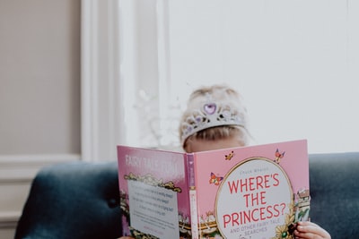 女孩正在读一本粉红色的公主书